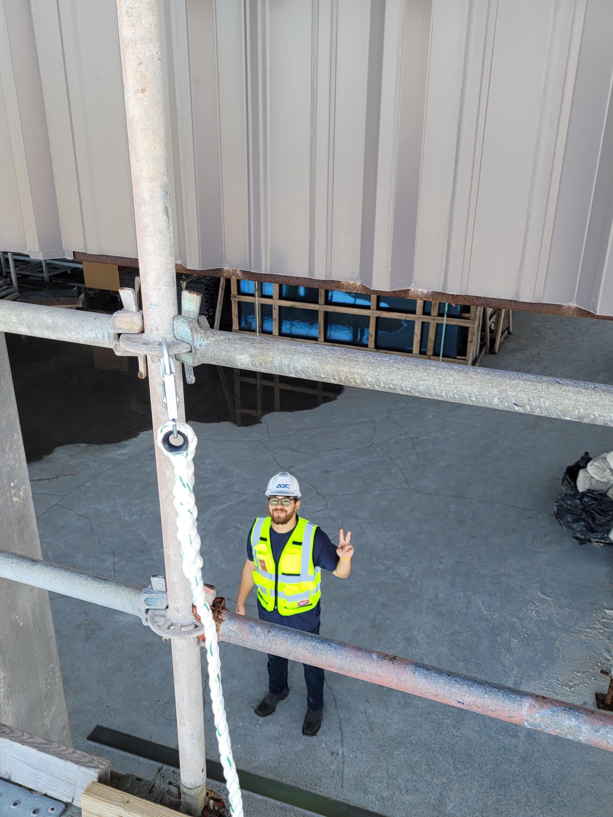 Worker on scaffold, peace sign